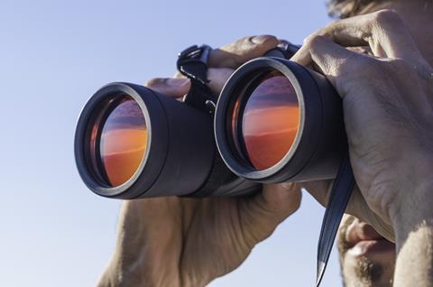 A man looking through binoculars