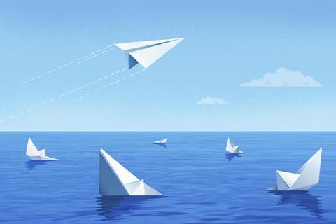 Paper boats sinking while paper plane flies off