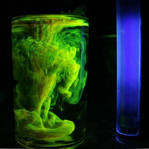Florescein powder dropped into a solution of tapwater under typical blacklight