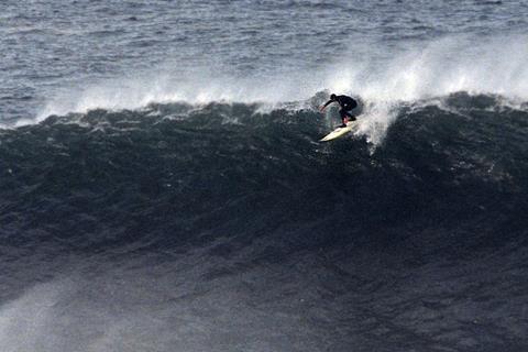 A surfer riding a very large wave