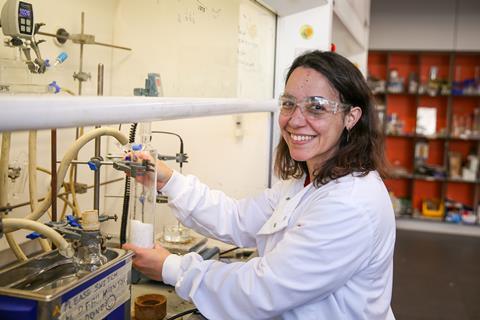 A woman working at a fume cupboard in a lab