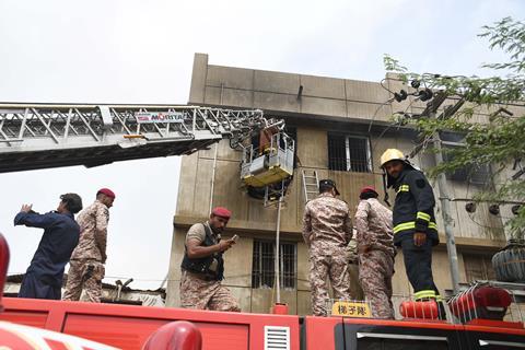 Firefighters and search and rescue personnel on the back of a fire engine