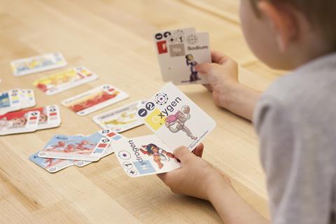 An image showing a child playing a chemistry card game