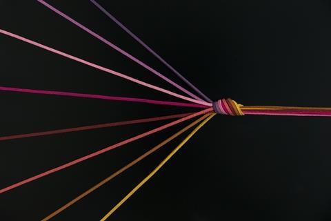 An image showing colourful suede cords converging into a knot which them continues as a complex thread