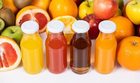 A photo of various fruit and fruit juices in glass bottles