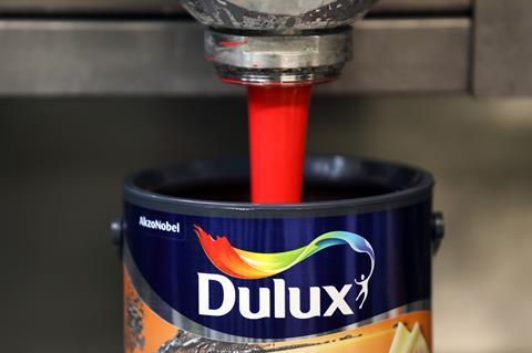 Dulux can being filled with red paint