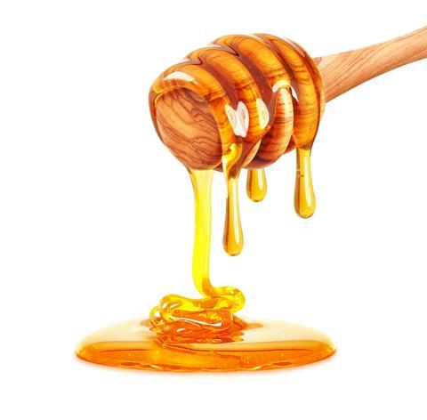 Honey dripping from a wooden honey dipper