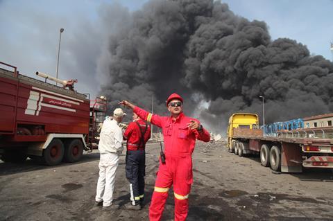 A firefighter coordiantes activity in the aftermath of a huge explosion at an Iranian port