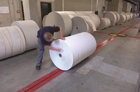 Man marking roll of printing paper