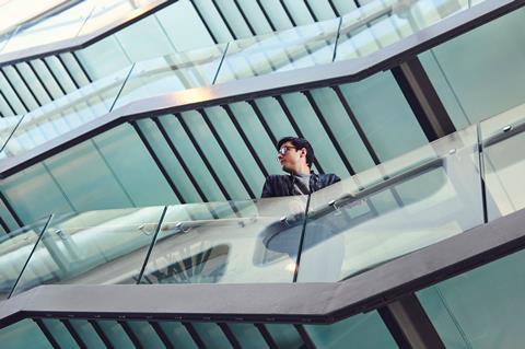 A portrait of Harry Destecroix in the stairwell of a modern glass building