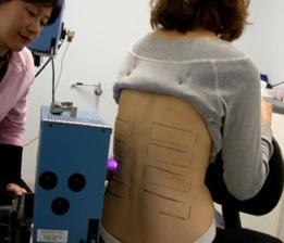 Woman having her back analysed by a machine