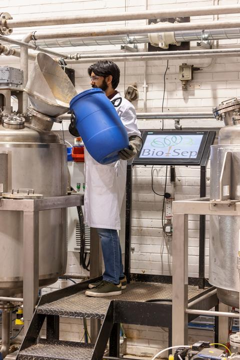 Rajesh Vega loading feedstock into the pilot plant