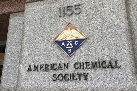 A sign and a crest on a marble building for the American Chemical Society