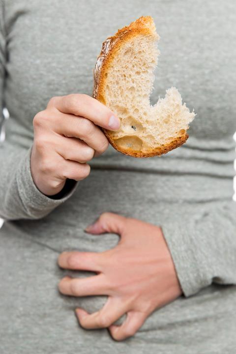  Woman holding wheat bread and having abdominal pain (celiac disease)