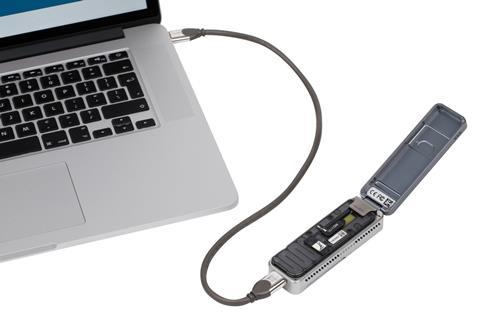 A small electronic device plugged into a laptop