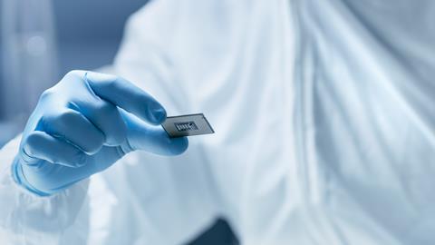 Gloved hand holding a silicon computer chip