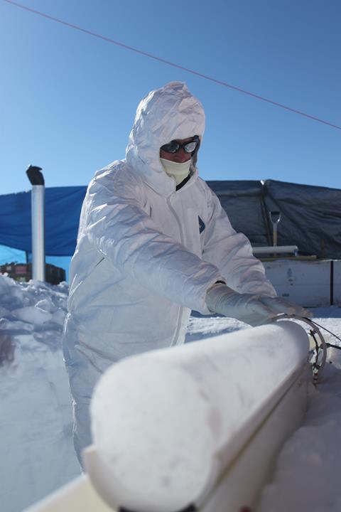 A photograph of a scientist working on an extracted ice core