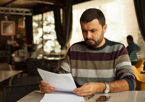 A photograph of a young academic reading a paper