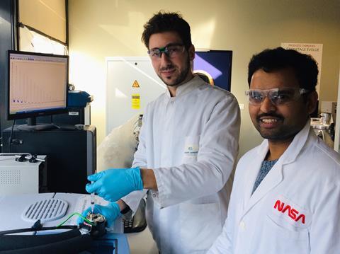 Photo of Lucas Lethuillier-Karl and Kalaivanan Nagarajan injecting a solution into a microfluidic infra-red spectroscopy cell
