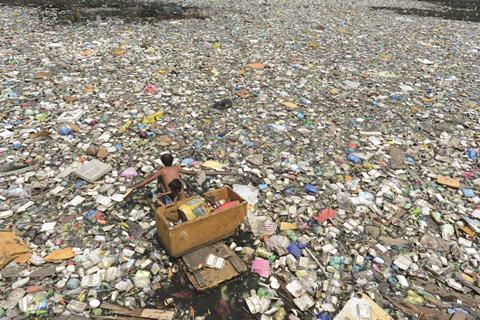 Collecting plastics from polluted river in Manila, Philippines