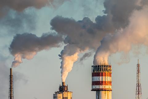 Air pollution by smoke coming out of many factory chimneys