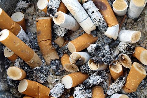 Background Ashtray full of used Cigarette Butts