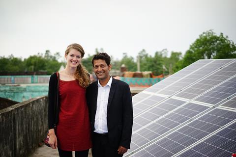Image showing Amit and Clem in India, with solar panels in the background