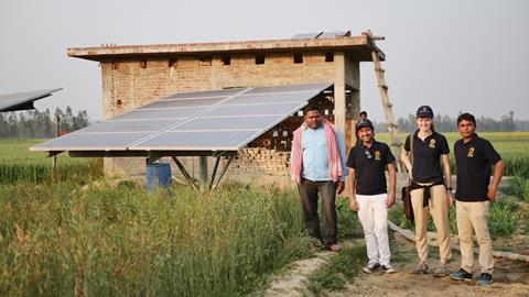 Image of the Oorja team in the countryside with a solar pump behind them