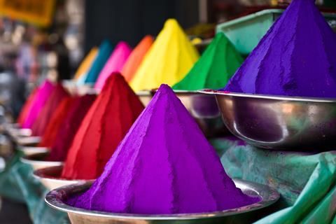 Piles of colored powders in an Indian market – holi colors