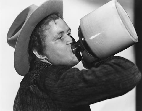 Man in cowboy hat drinking from a jug