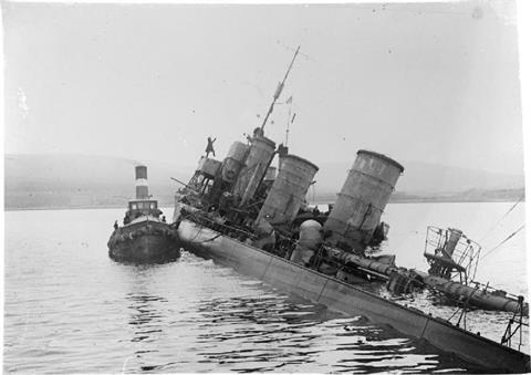 Tug alongside scuttled German destroyer G 102 at Scapa Flow