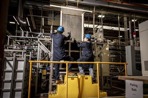 Employees guide a cathode coated with 99% pure iron out of an electrowinning cell at the Electra production facility in Gunbarrel, Colorado, US
