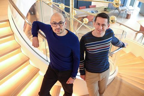 Demis Hassabis and John Jumper stand together on a spiral staircase