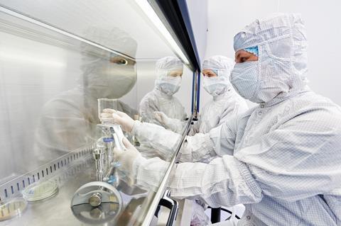 A photograph of laboratory researchers in protective uniform