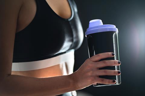 Woman holding a gym shaker bottle 