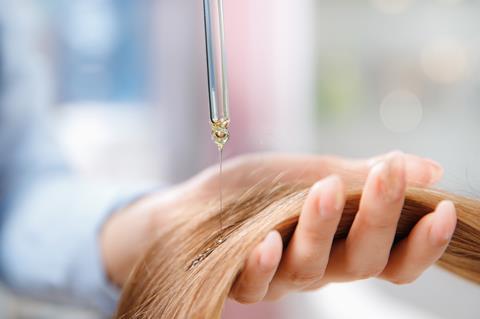 Hand using a pippette to apply keratin hair treatment