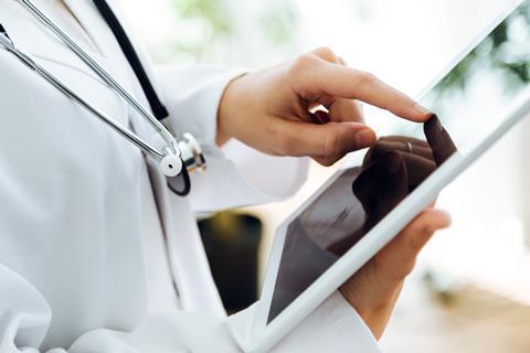 Portrait of female doctor using her digital tablet in the office.