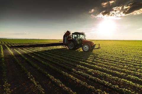 An image showing a tractor spraying crops