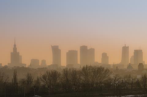 View across Warsaw skyline showing in sunset with smog and dust in the air