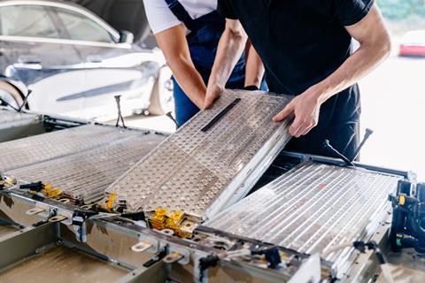 Technicians fitting batteries into an electric vehicle