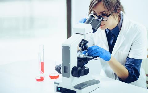 Researcher using a microscope