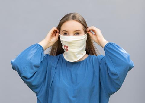 An image showing a woman putting on a Virustatic face shield