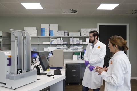 Exscientia scientists look at results on a lab computer