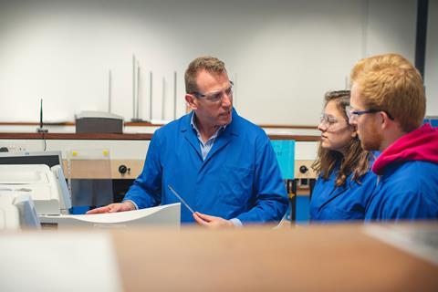 A instructor showing students how to use some lab equipment