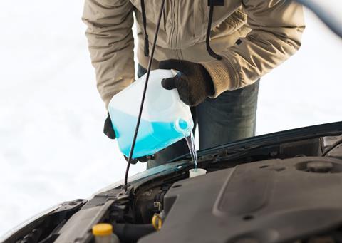 man pouring antifreeze into windscreen water tank 