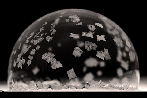 A photograph of a bubble freezing on a block of ice held in a walk-in freezer