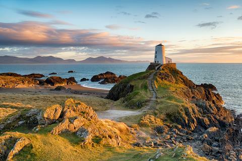 Sunset at Ynys Llanddwyn island on the coast of Anglesey in North Wales with the mountains of Snowdonia in the distance 