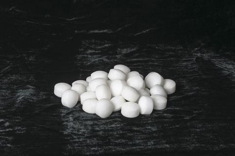 White naphthalene balls on black velvet 