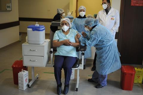 An image showing a health worker receiving the Sputnik vaccine