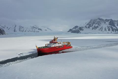 RRS Sir David Attenborough with its bright red hull sailing through thin ice